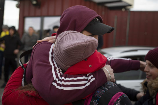 two persons hugging one another wearing warm clothes