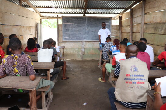 a classroom with wood board walls and an earth floor