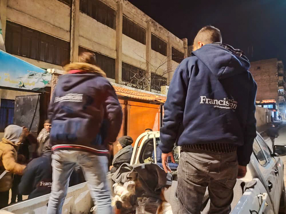 people unloading food packages in a pick up truck