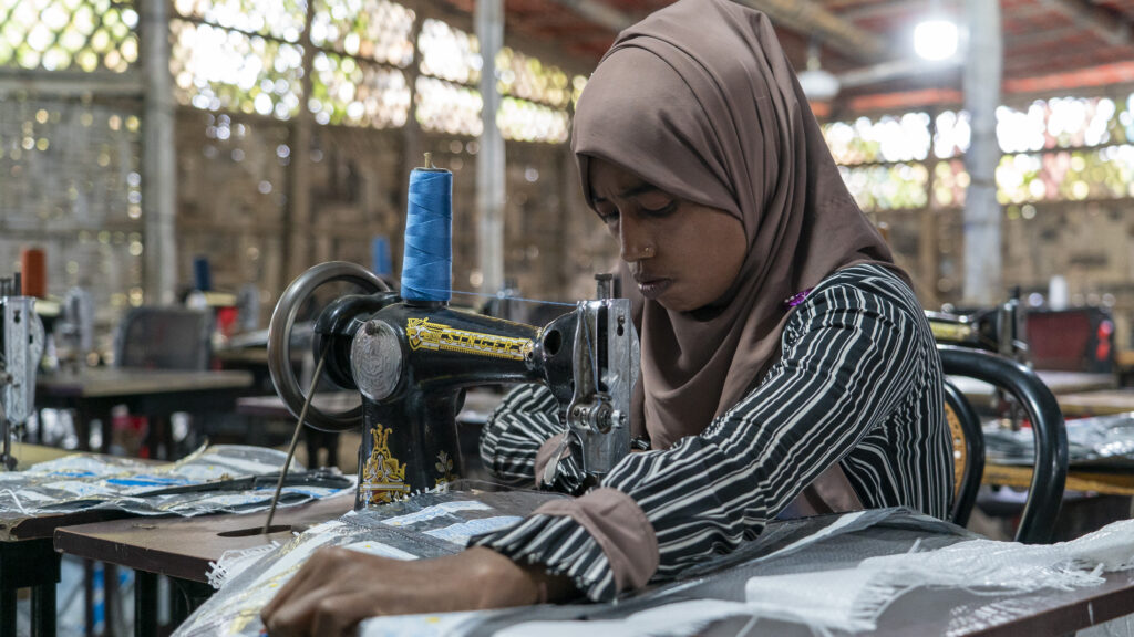 A Rohingya refugee woman sewing.