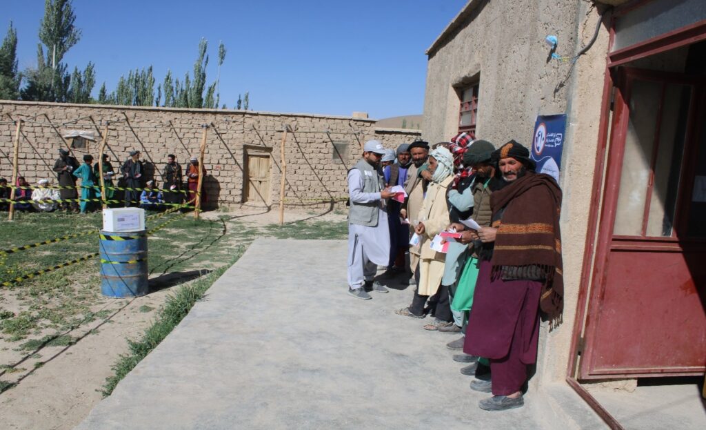 People waiting in line at a humanitarian distribution point in Afghanistan.