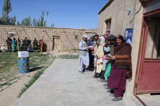 People waiting in line at a humanitarian distribution point in Afghanistan.