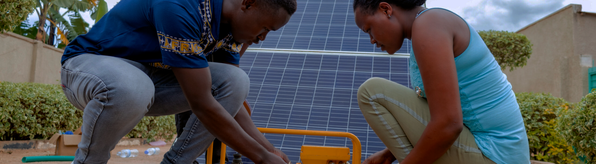 Rwandese youth working on a solar panel.