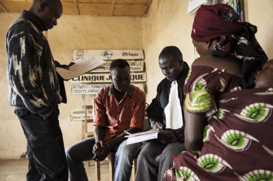 a legal aid professional with some persons doing paperwork inside a room