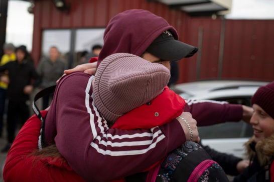 two persons hugging one another wearing warm clothes