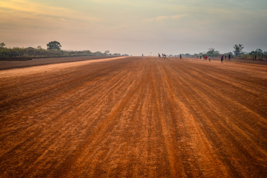 kids playing on airstrip red dirt road
