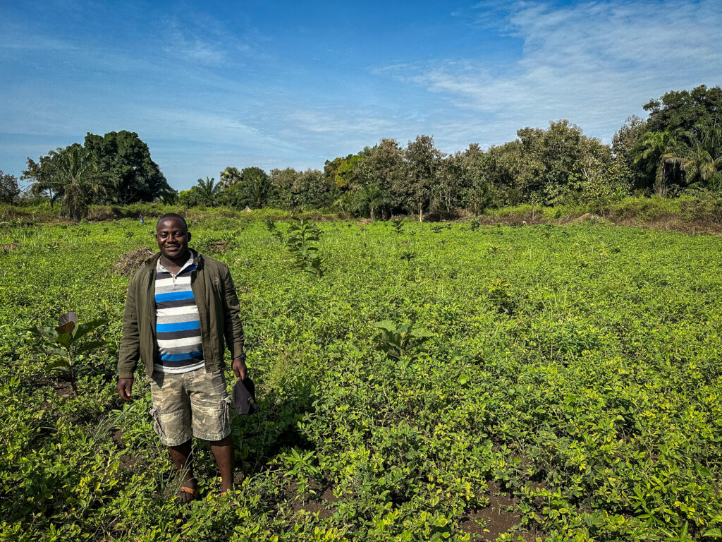 man standing in a lush green setting with blue skies above