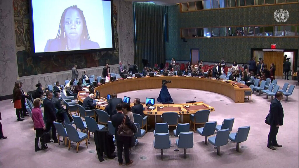 big screen in the UN security Council main room, showing the face of a young woman