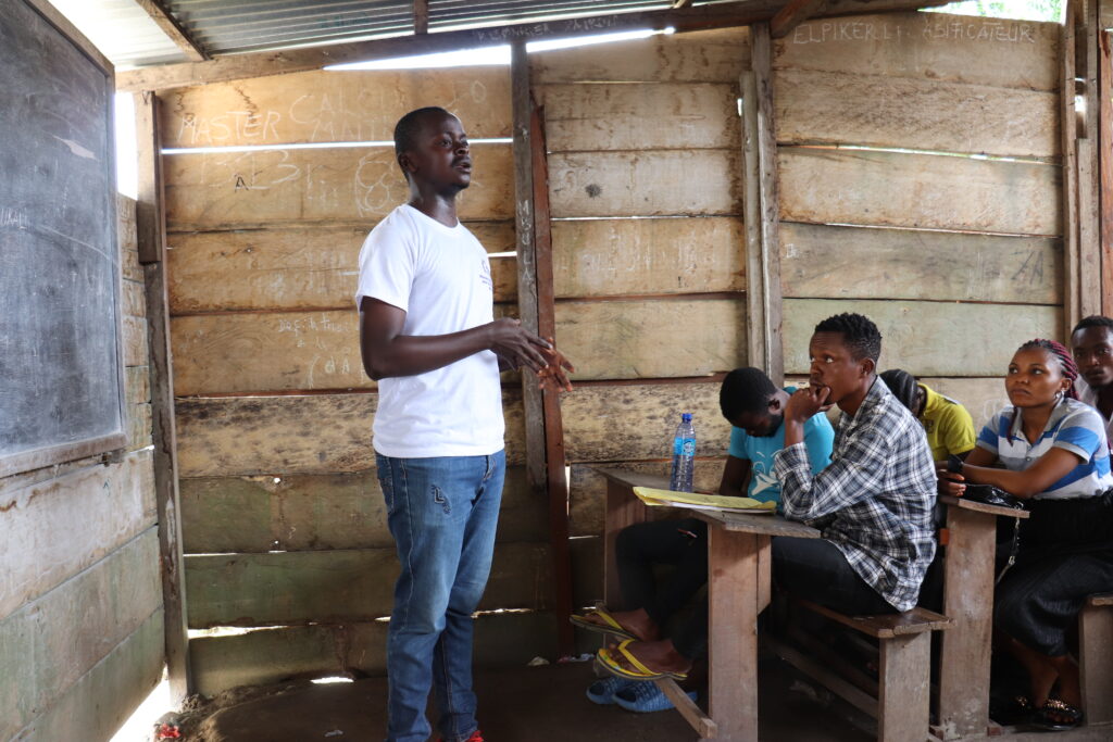 man standing in front of others that are seated in a classroom