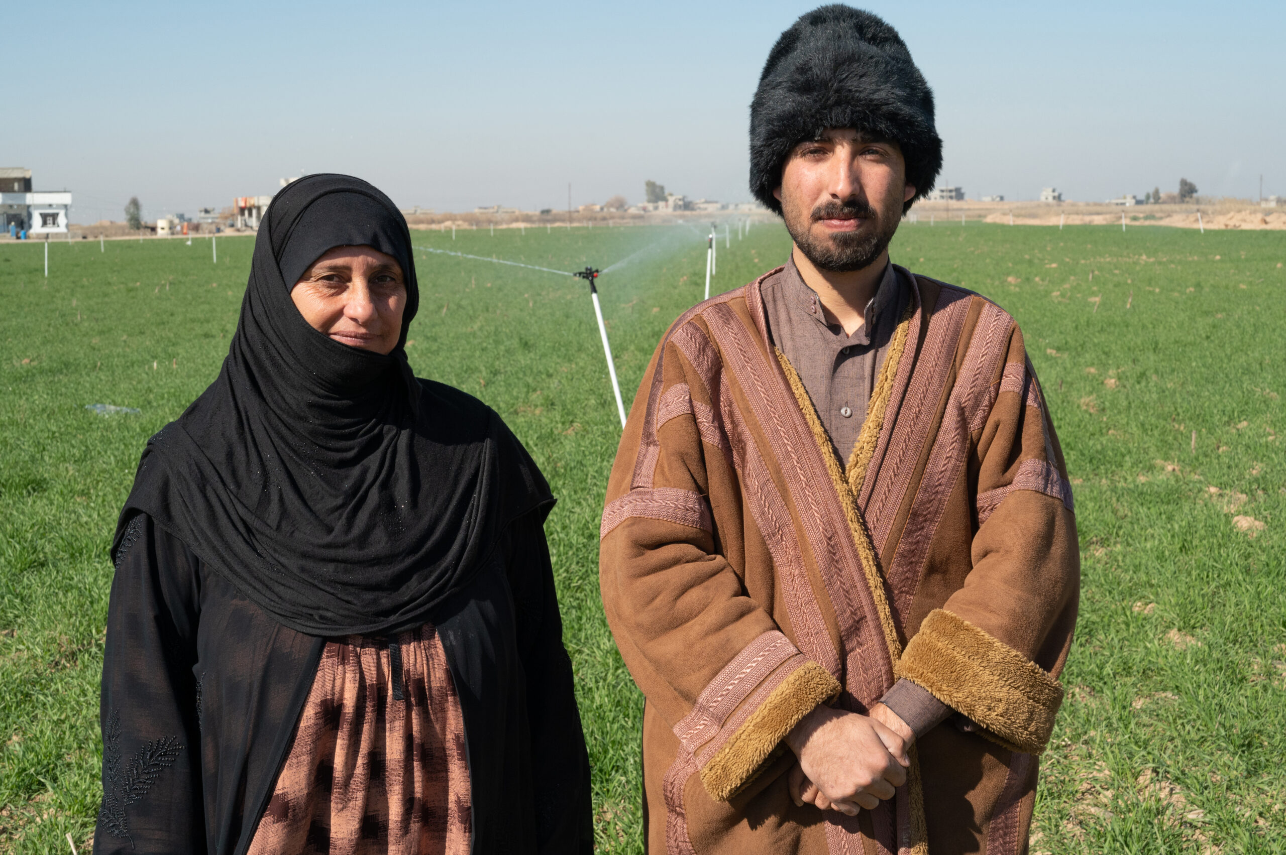 man and woman standing in field