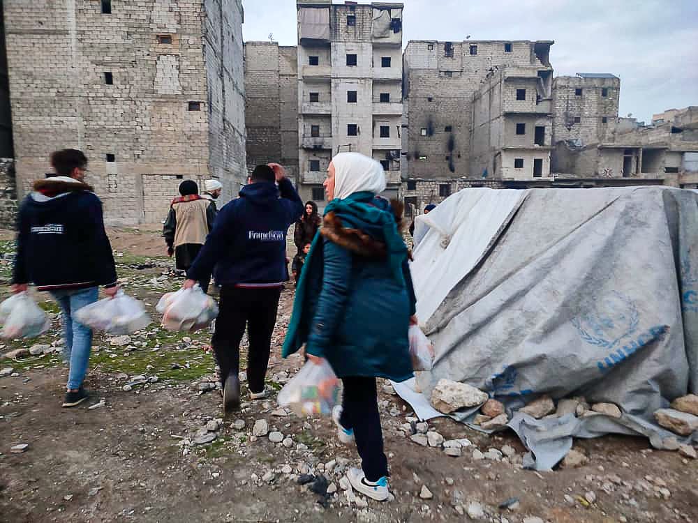 tent abandoned houses people carrying bags