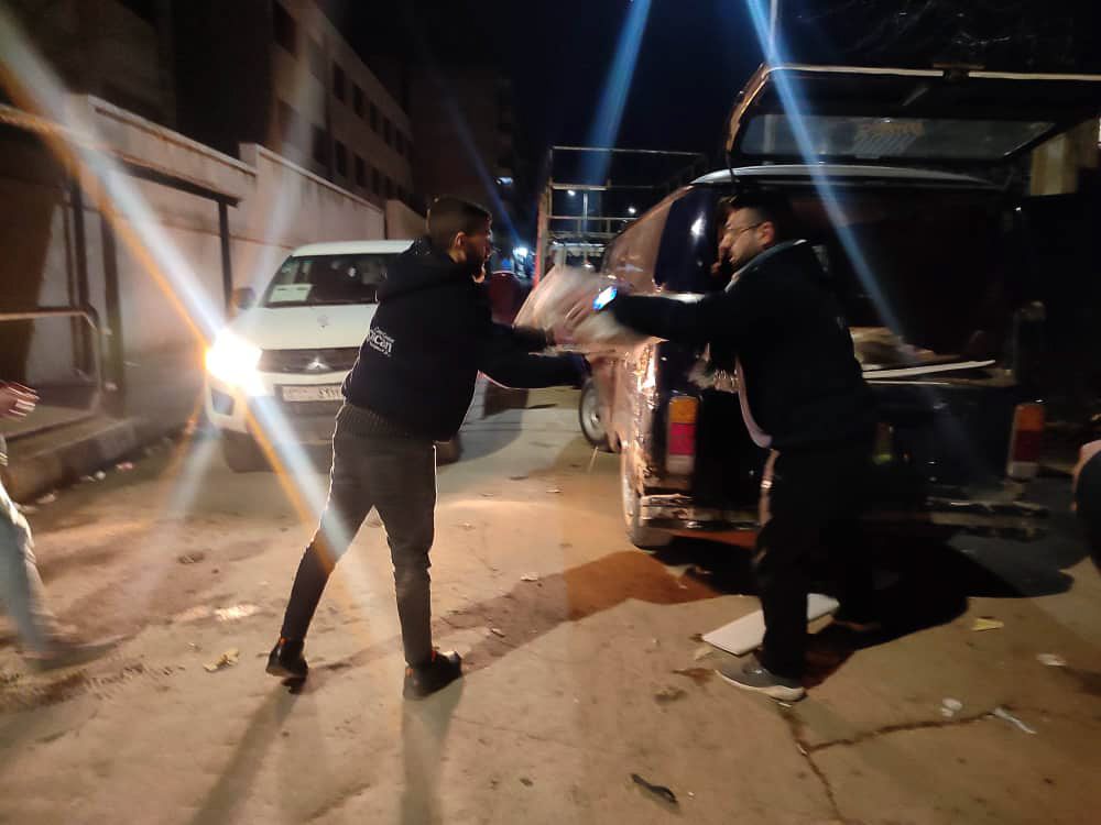 people unloading food packages in a pick up truck