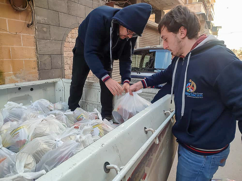 people unloading food packages in a pick up truck