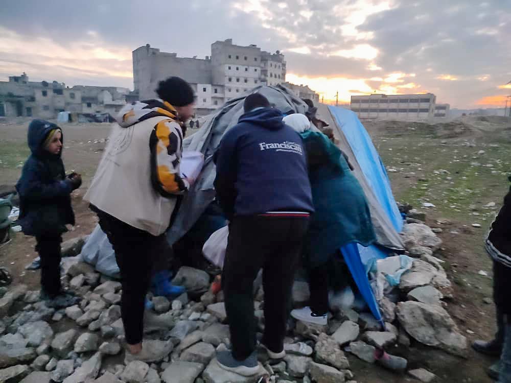 people around a makeshift tent