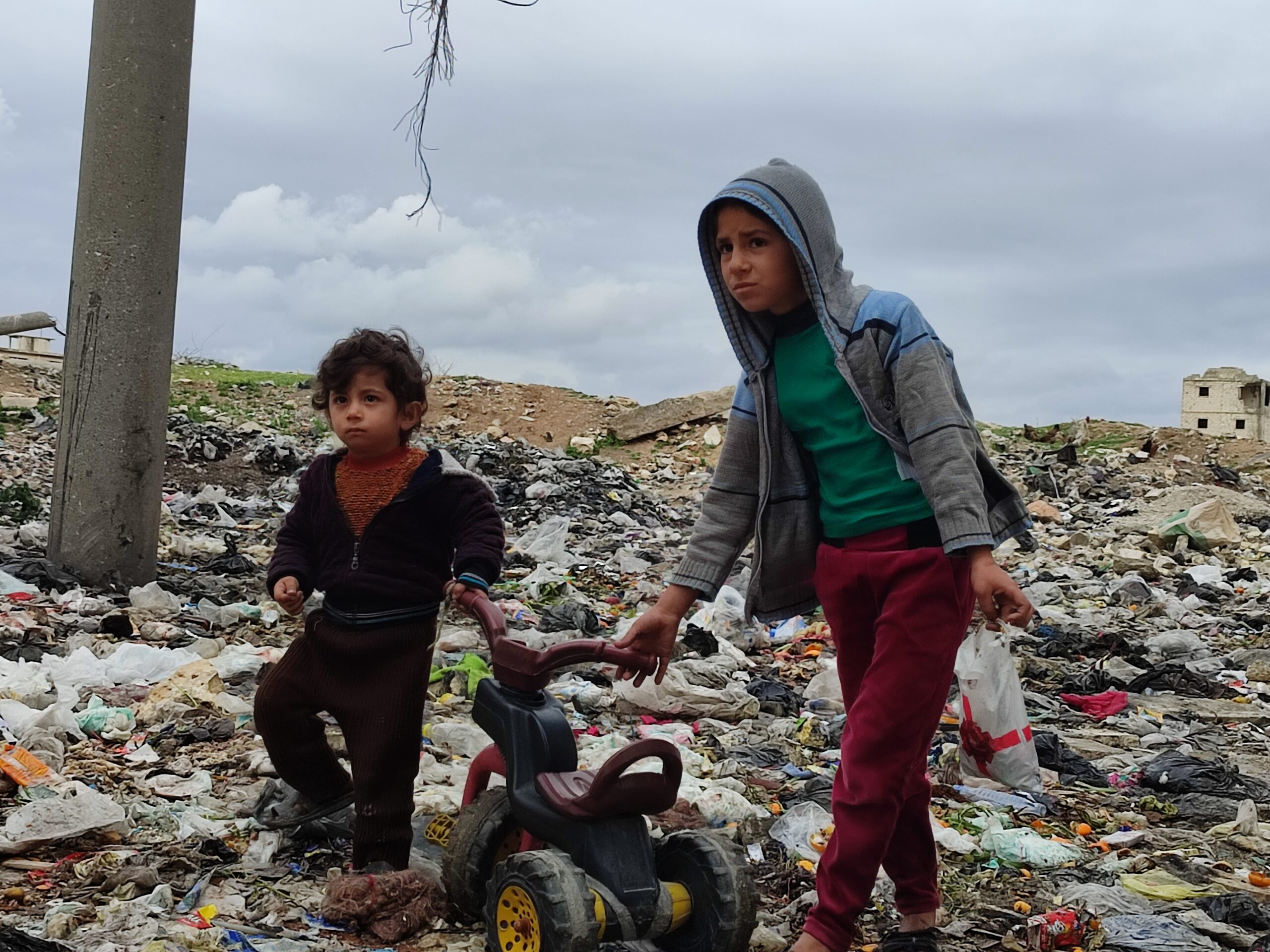 young boys among rubble and garbage