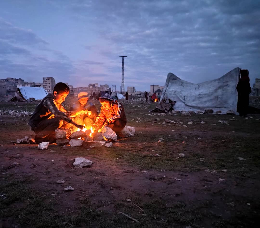 boys around a fire evening tents