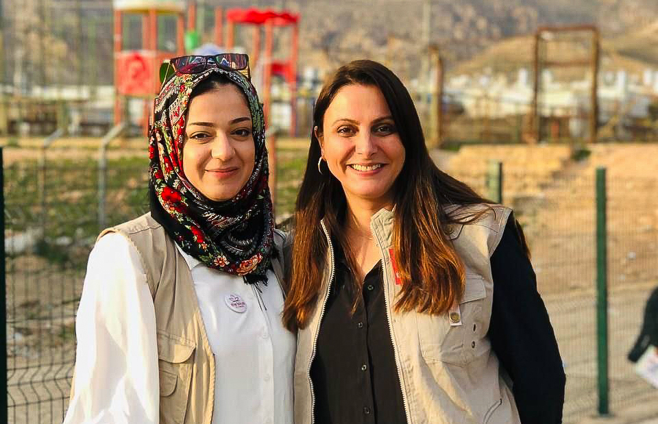 two women standing looking into the camera smiling