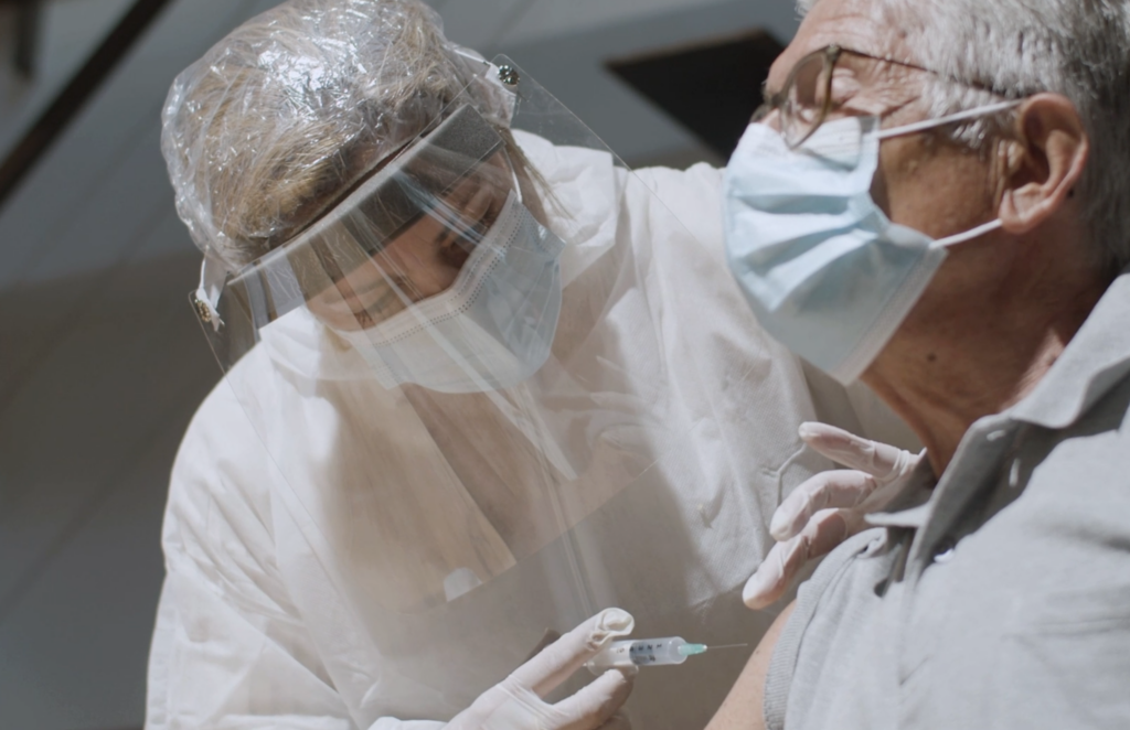 Man receiving vaccine from health worker