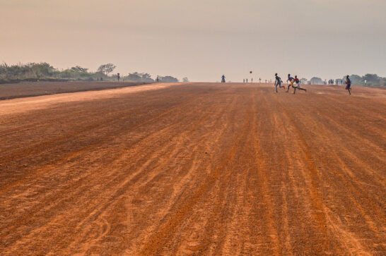 Villagers playing football on an airfield outside of Bossangoa