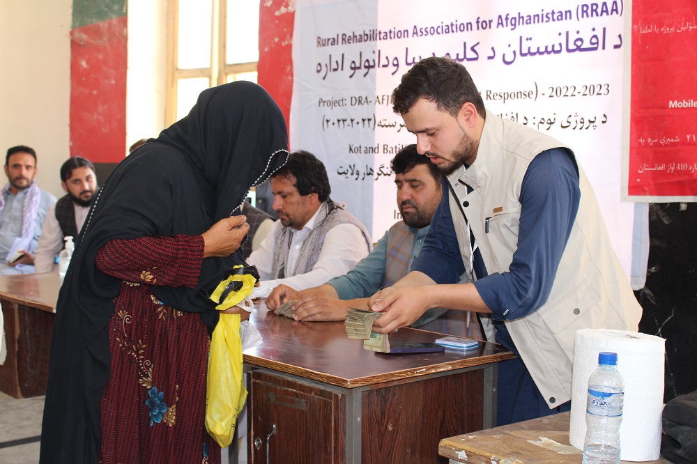 Afghan humanitarian workers distributing cash.