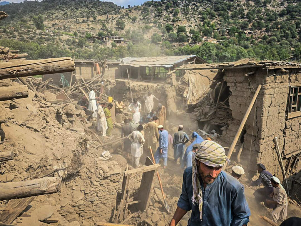 Afghanen zoeken na een aardbeving naar overlevenden.
