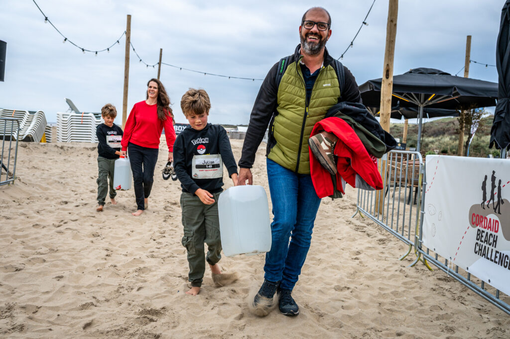 Deelnemers Cordaid Beach Challenge 2025 lopen laatste meters met jerrycan water