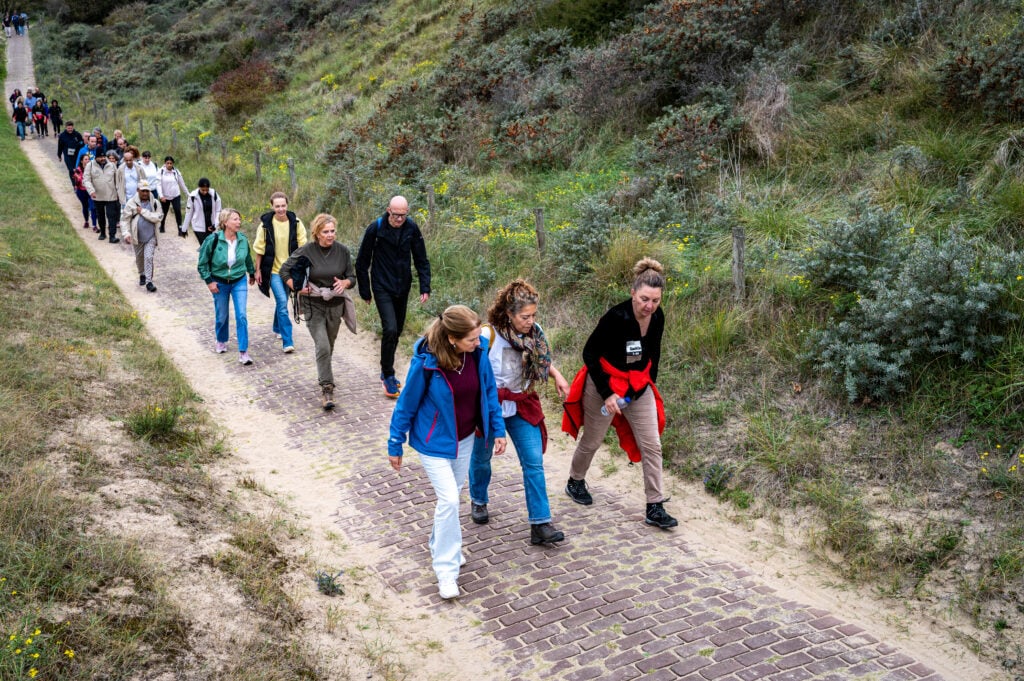 Deelnemers Cordaid Beach Challenge 2025 stappen door in duinen van Scheveningen