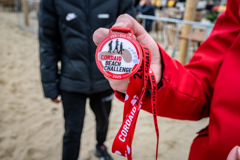Hand met medaille Cordaid Beach Challenge 2025