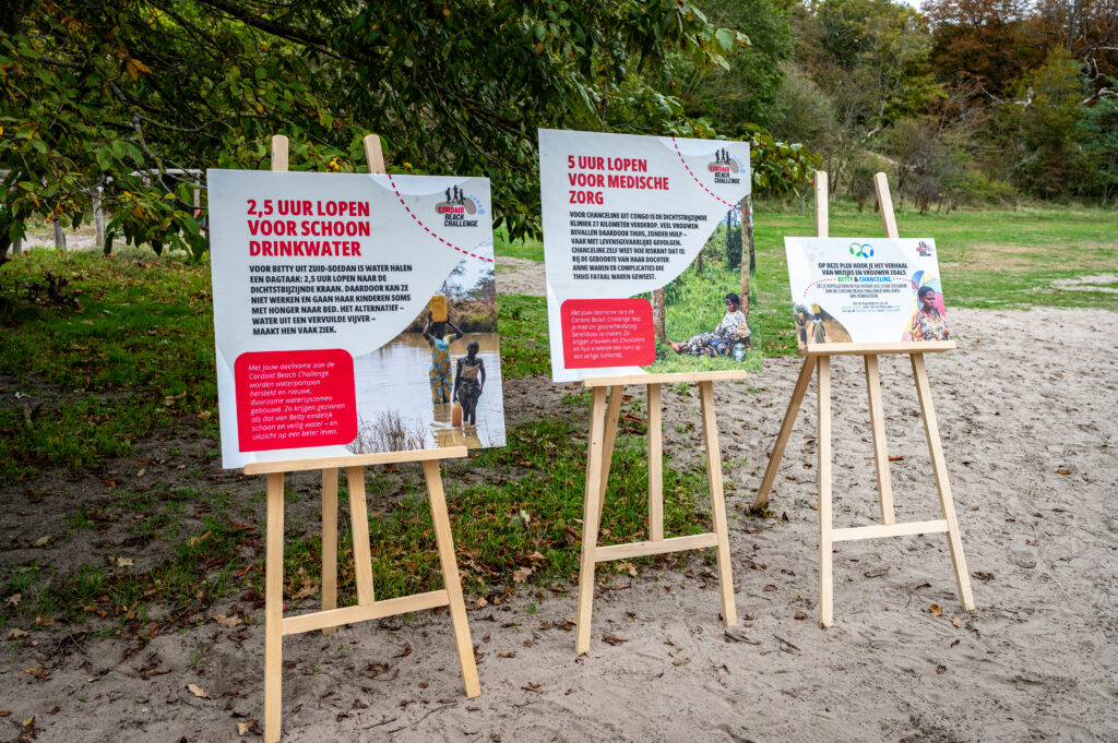 Borden met verhalen over gezondheidzorg en schoon drinkwater bij rustpunt van Cordaid Beach Challenge 2025