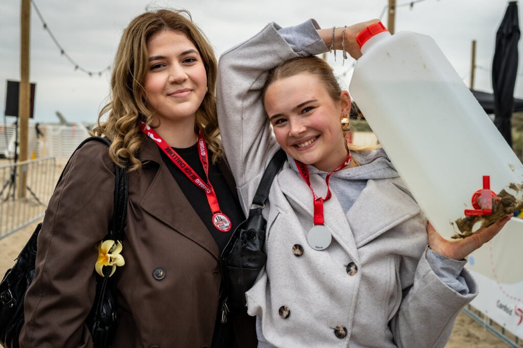 Wandelaars Cordaid Beach Challenge 2025 met jerrycan water op rug bij de finish