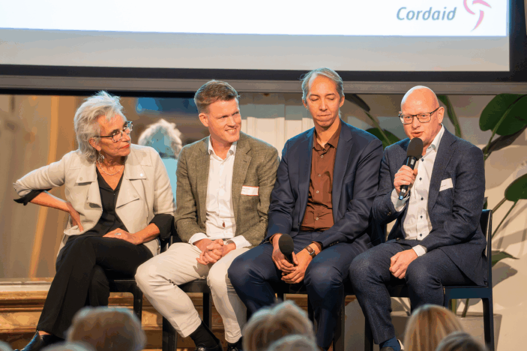panelleden voeren gesprek op padium bij 100-jarig jubileum gezondheidswerk Cordaid