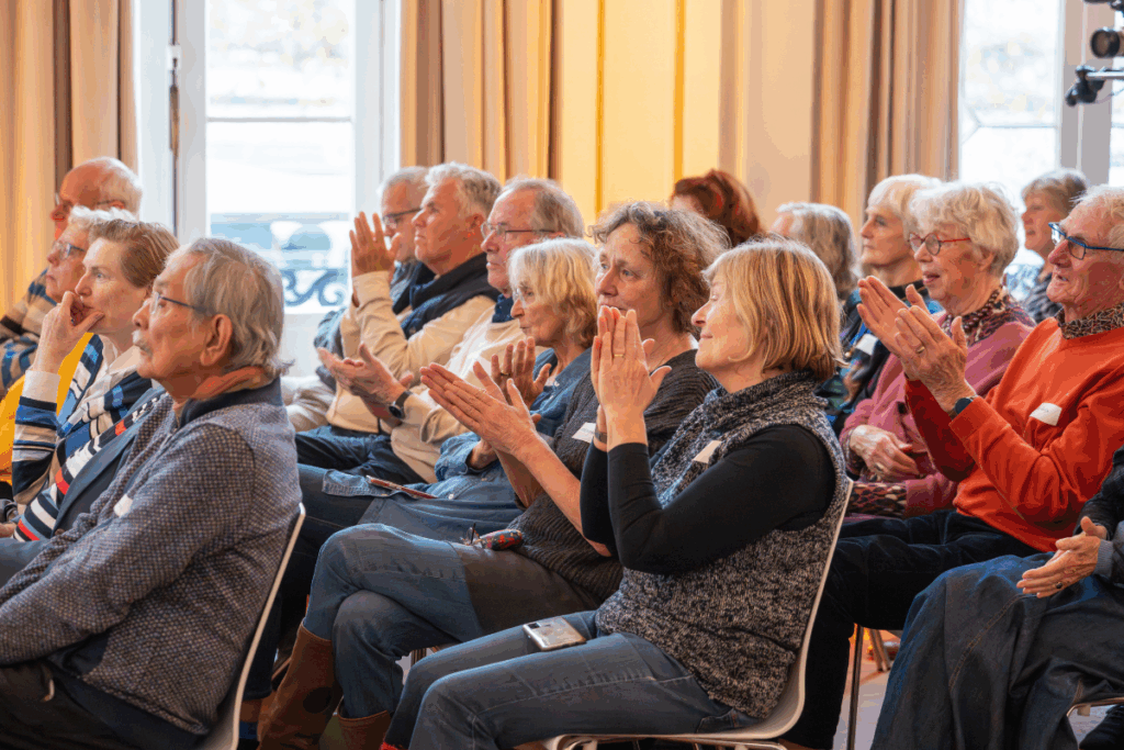 Publiek applaudisseert bij 100-jarig jubileum gezondheidswerk Cordaid in Wereldmuseum Rotterdam