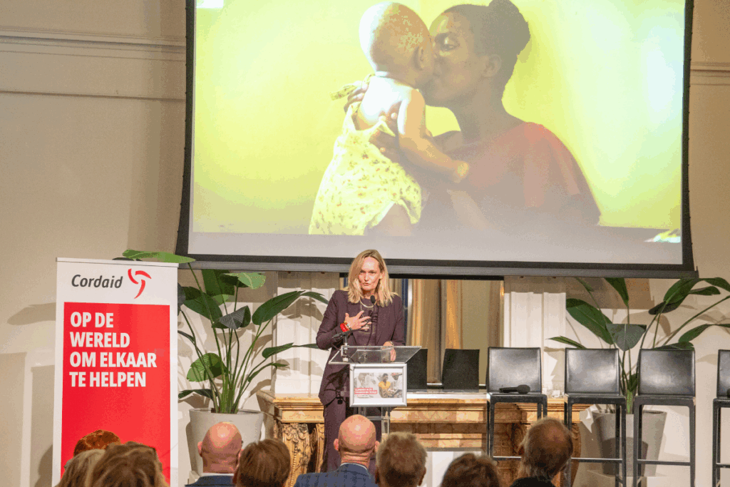 Directeur Cordaid Heleen van den Berg op podium bij 100-jarig jubileum gezondheidswerk Cordaid