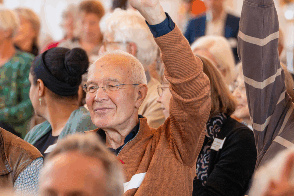 Man beantwoordt vraag in publiek bij 100-jarig jubileum gezondheidswerk Cordaid