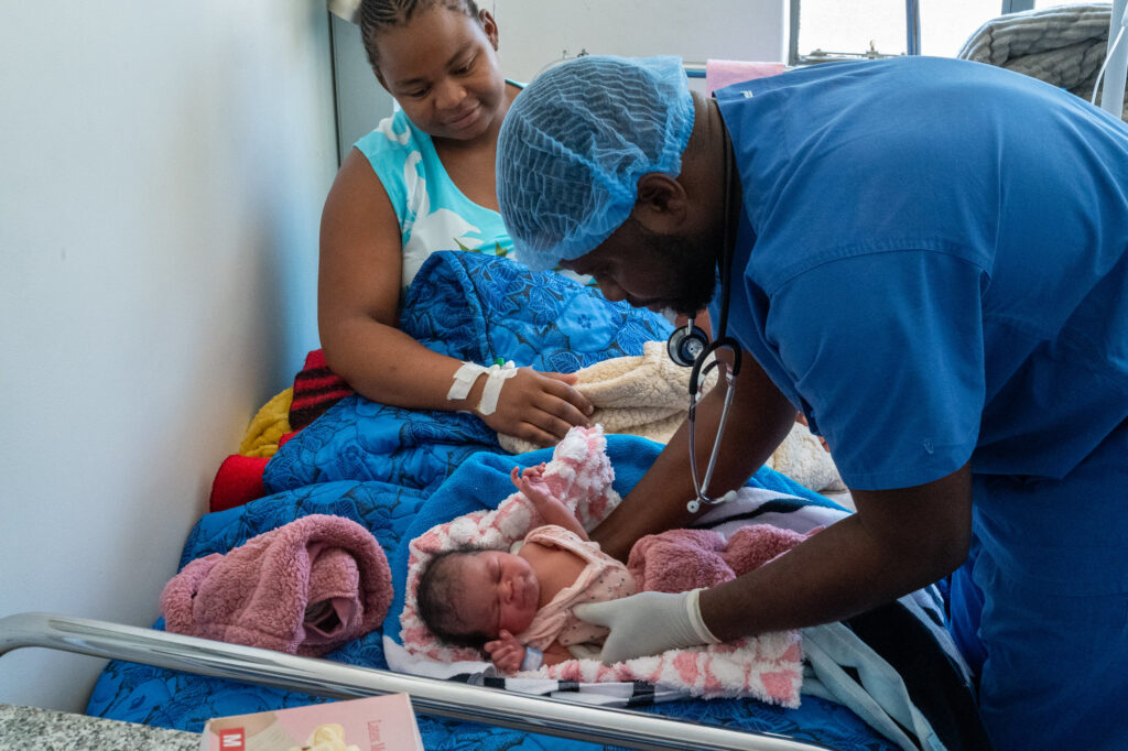 Een Zimbabwaanse dokter verzorgt een moeder en haar baby.